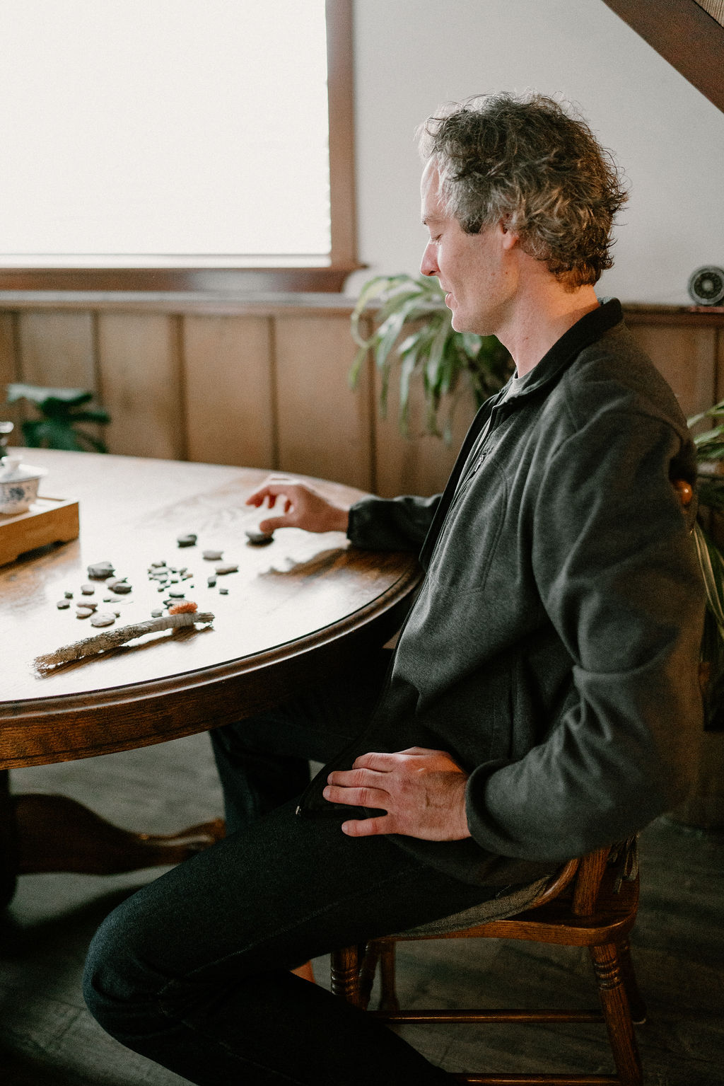 Sean at a table with stones and sea glass